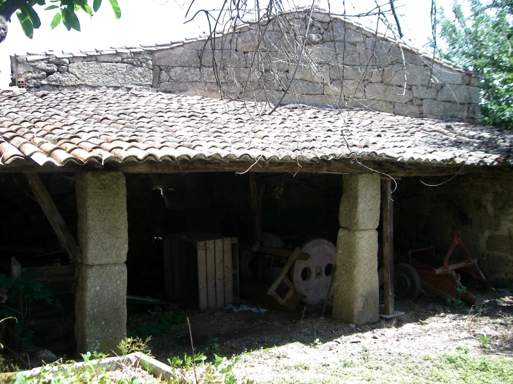 a shed with several objects in it near some trees