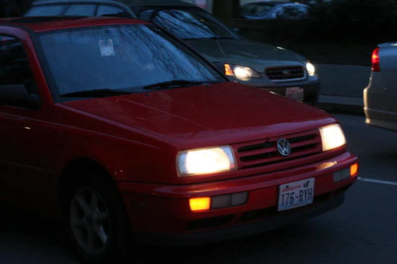 a red vw golf parked on the side of the road