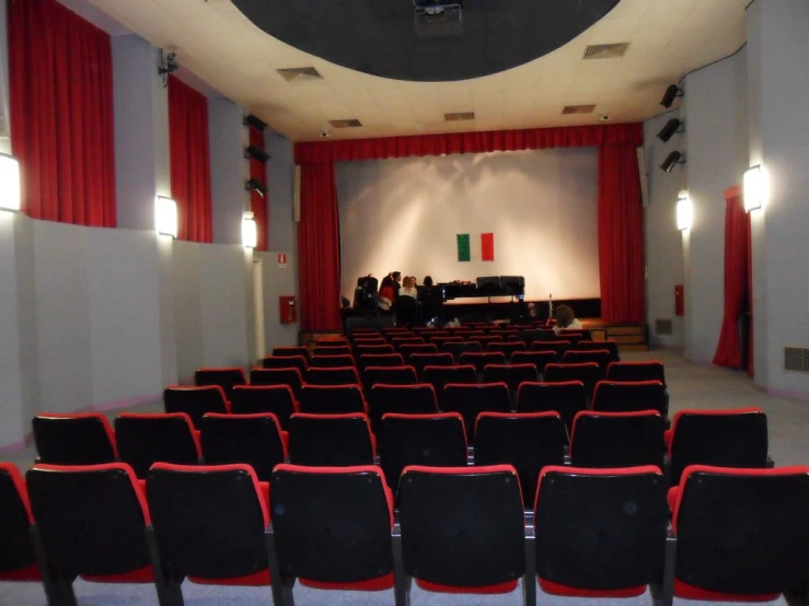 auditorium with red curtains and black seats facing on stage
