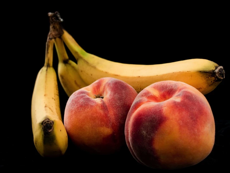 fruit and a banana against black background