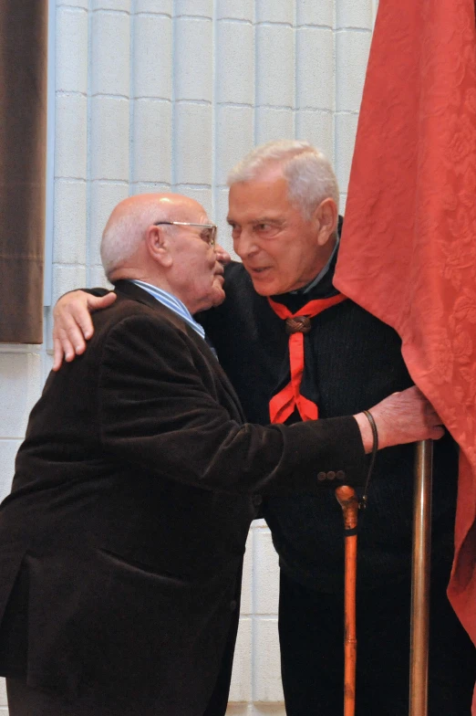 two men hugging each other in front of flags