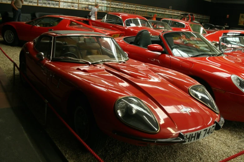 several old style sports cars are lined up for show