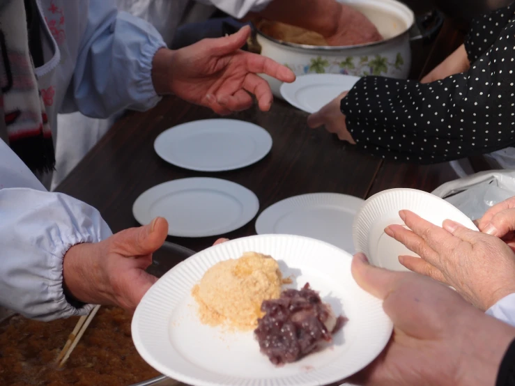 a group of people holding plates of food at a party