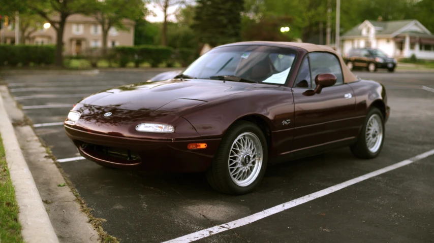 a maroon sports car parked in a parking space