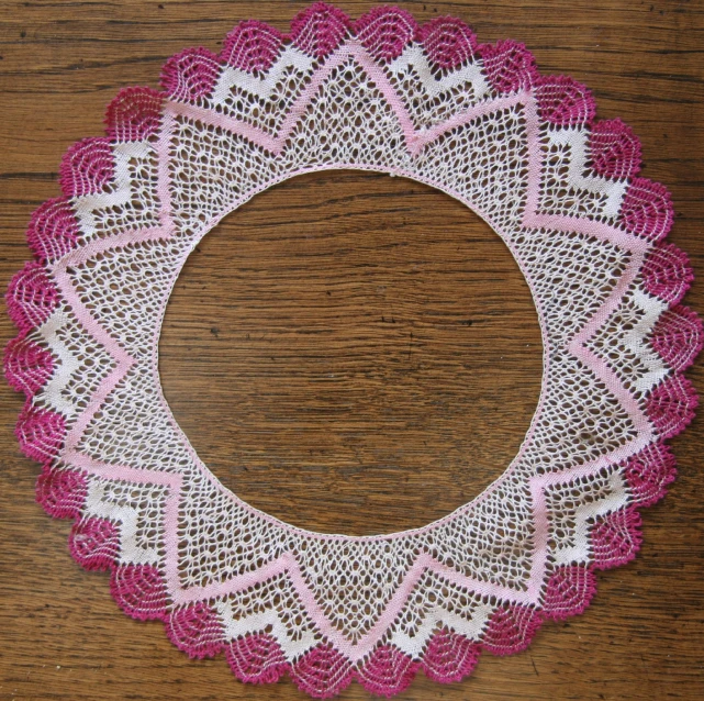 there is a pink and white doily that looks like an intricate circular