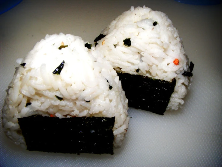 rice balls are coated with black meat and garnished with black sesame seeds