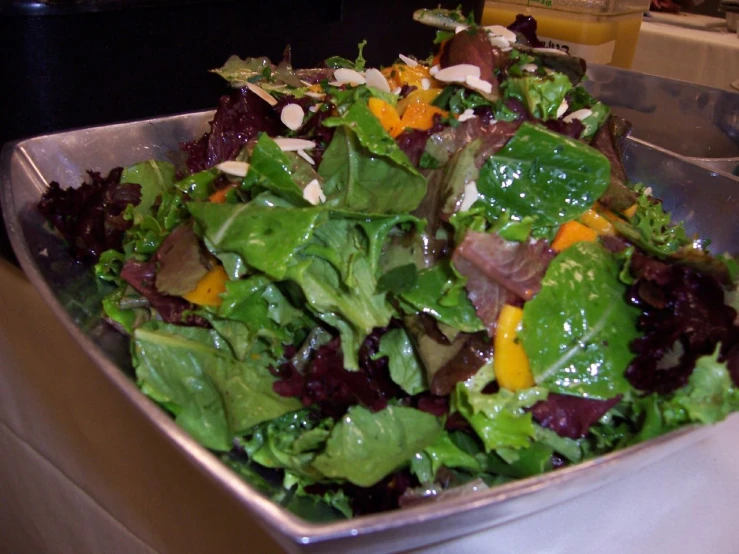 a salad in a stainless steel bowl is being displayed