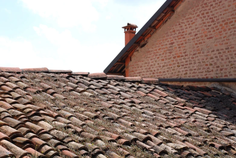 an old, run down roof has been left with many damaged shingles and a weather guard