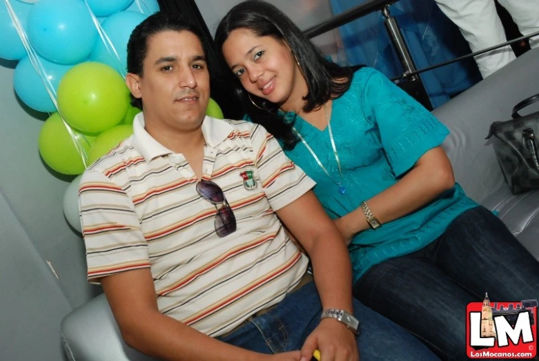 a couple is posing for a picture in front of balloons