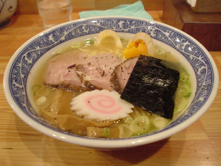 this is a bowl of colorful soup with some meat and vegetables