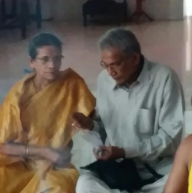 an old man and young woman sitting down talking