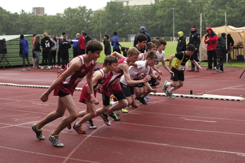 a group of people on a track with one in the middle of a race