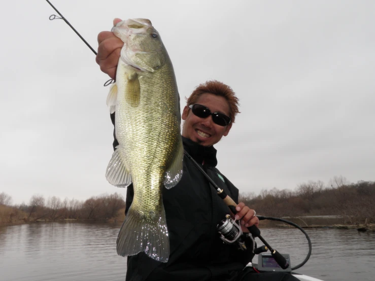 a man on a boat holding a large fish