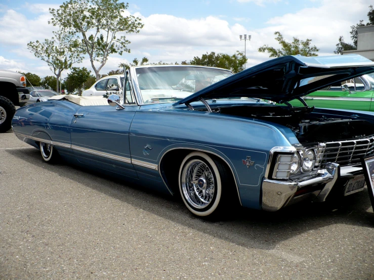 there is an old blue car parked in the lot