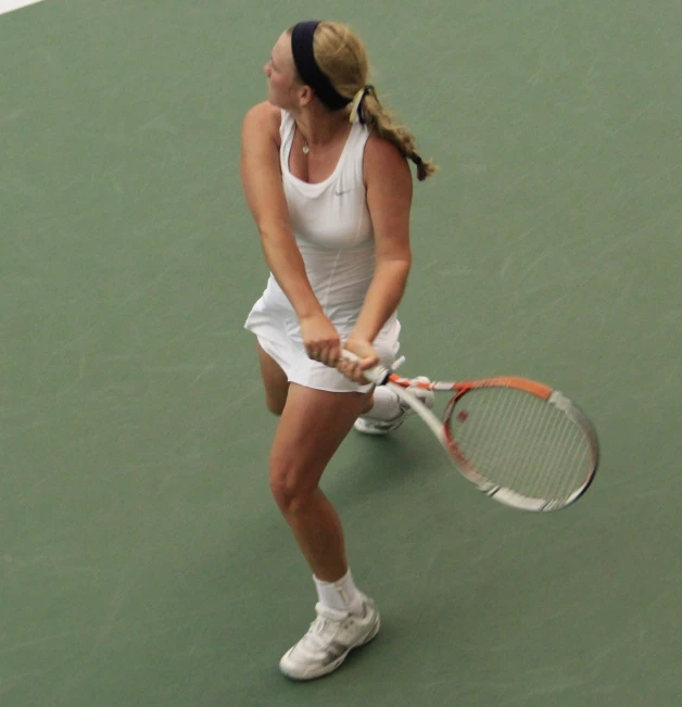 a young lady standing on top of a tennis court holding a racquet