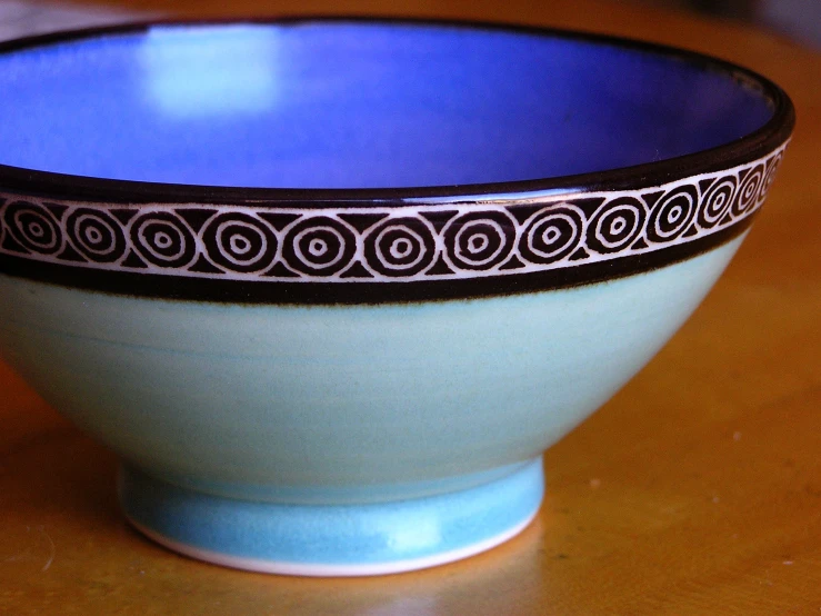 a small bowl with a black and white decoration on the rim