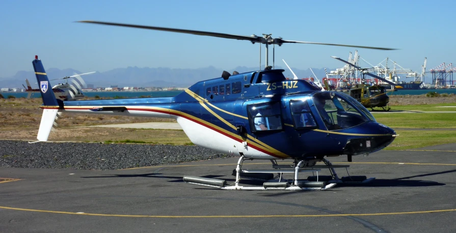 a close up of a small blue and white helicopter on a runway