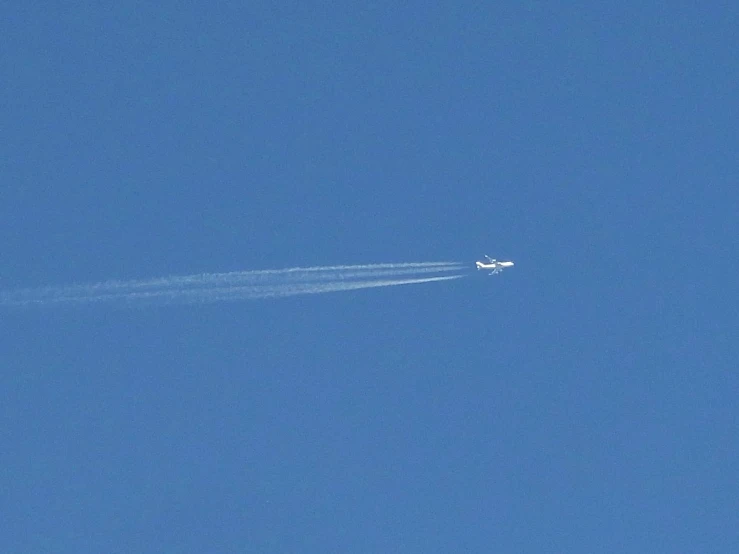 a plane flying overhead leaving a trail of smoke