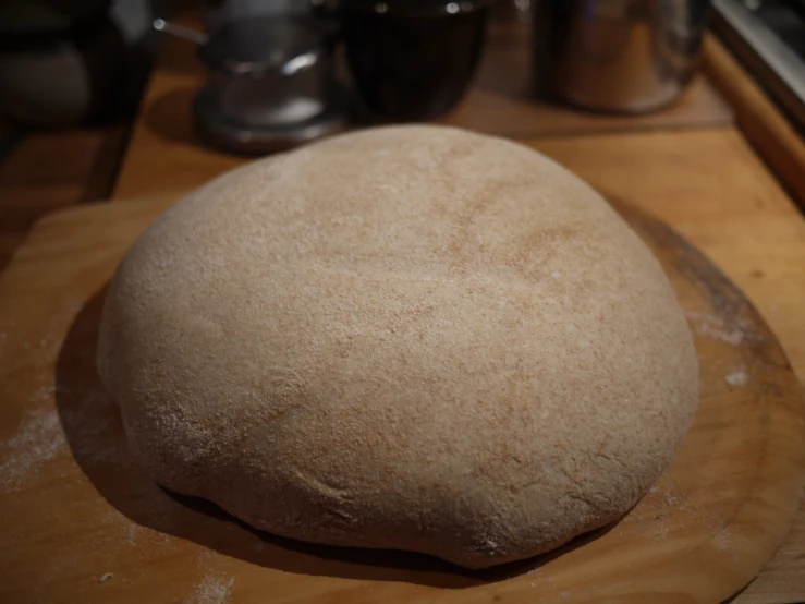 a large round doughnut sitting on top of a wooden board