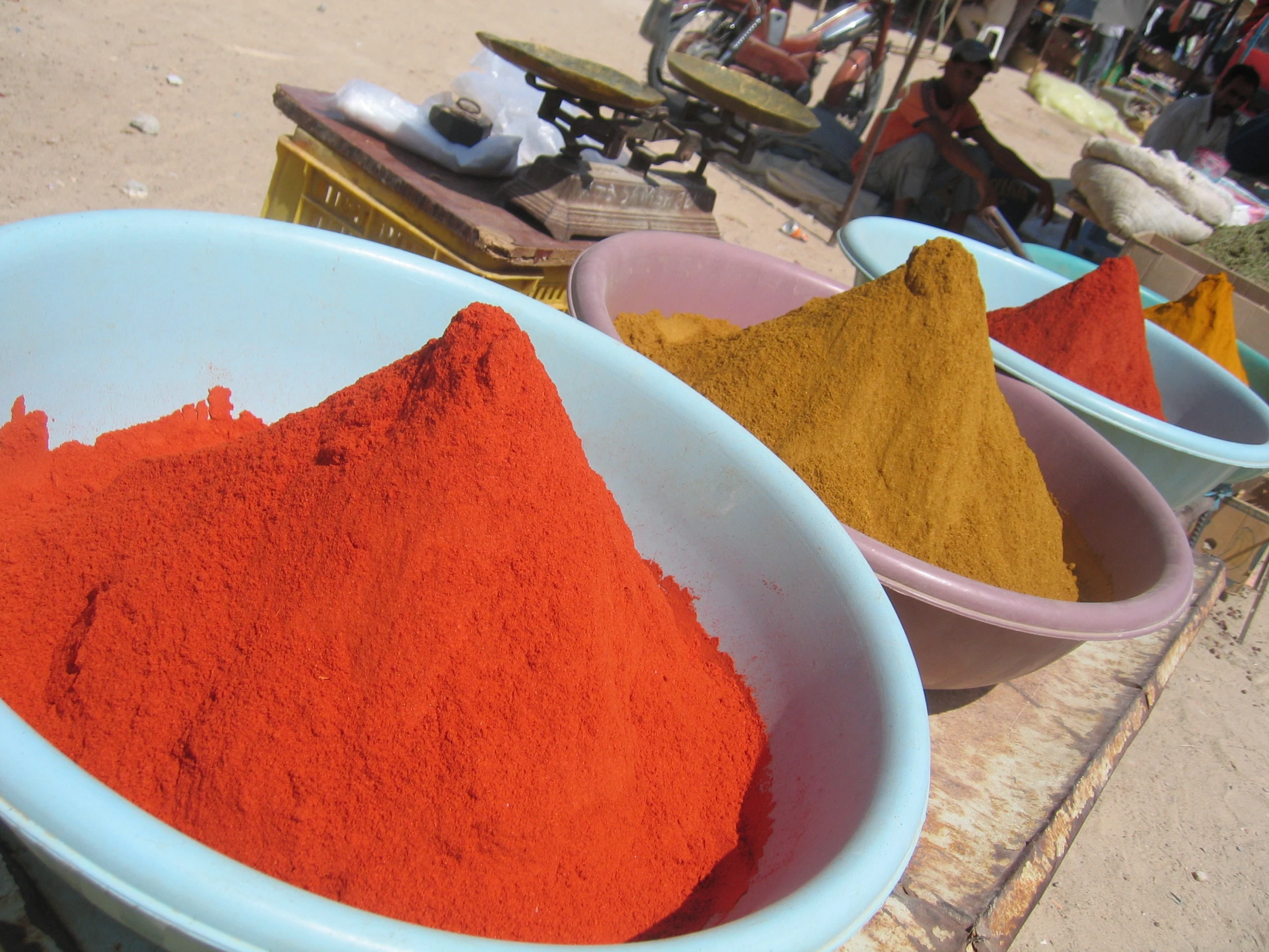 red and orange sand are in bowls with people