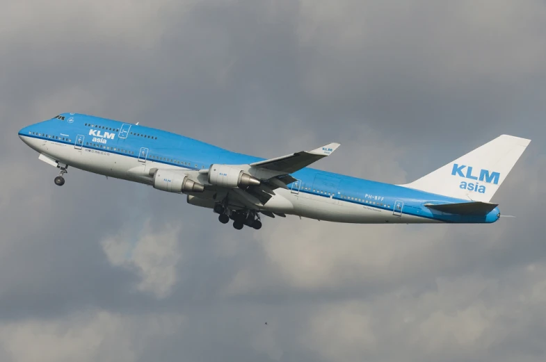 a blue and white airplane is flying in the sky