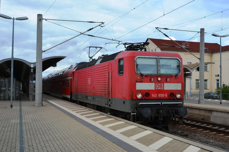 a red train sitting on a track next to a station