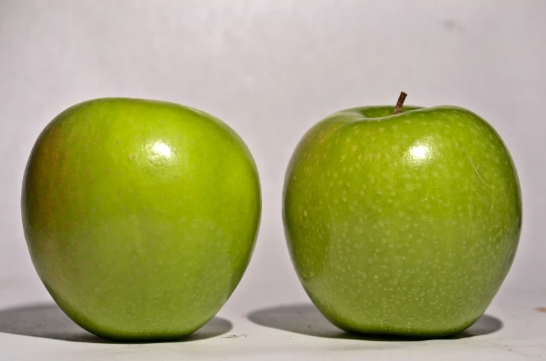 an apple standing up against the camera with it's head turned to look like a human face