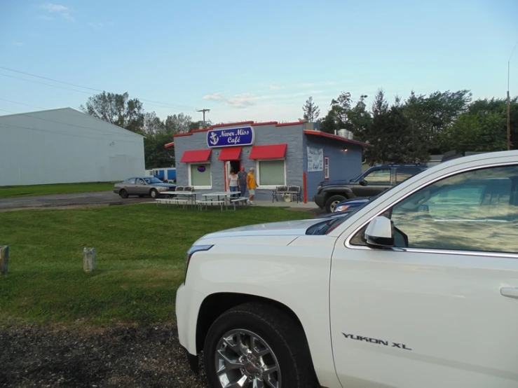 a white truck is parked outside a restaurant