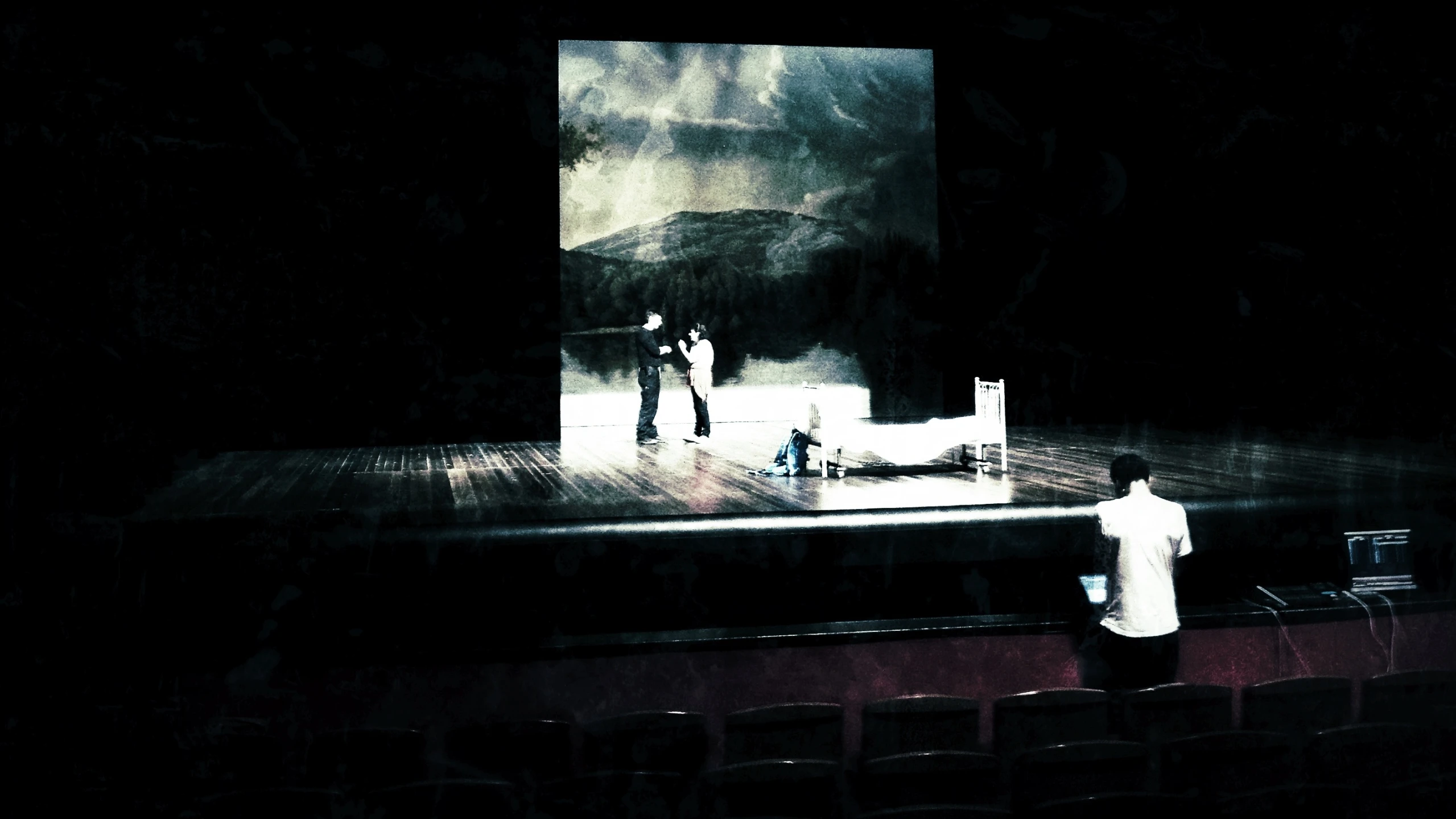 a stage with chairs and a man standing on a stage