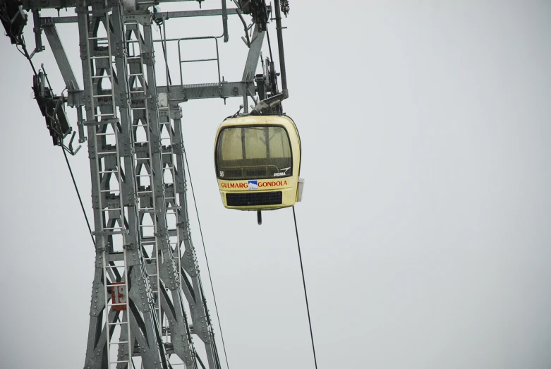 a yellow train going up the side of a tall structure