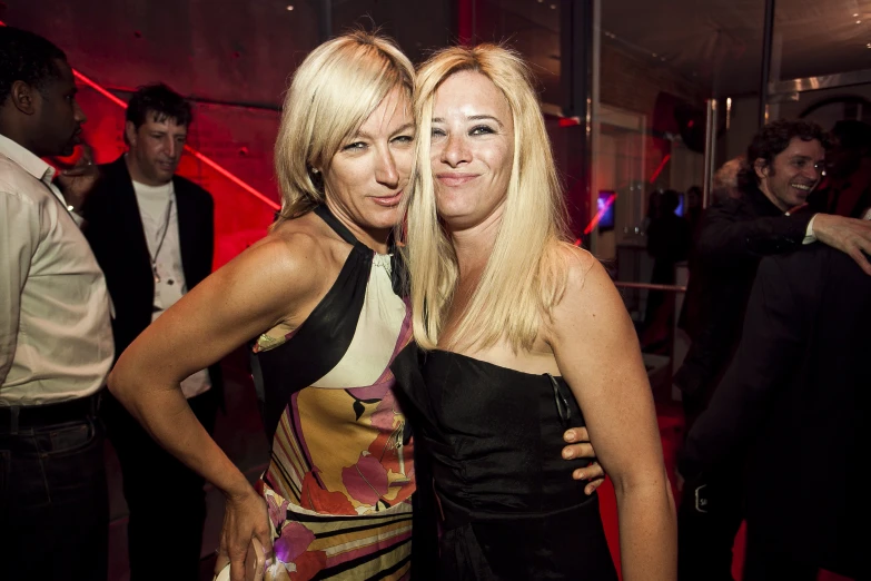 two young women pose for a po at an event