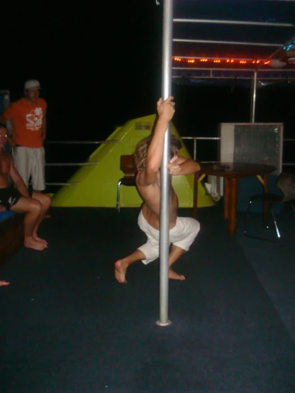a person that is standing on one leg, under a pole