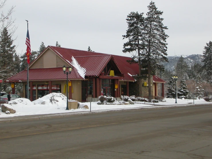 a store with a red roof is shown in winter