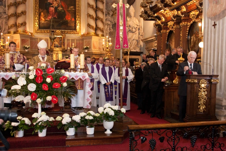 several men and women are gathered at a alter, one in front of the camera