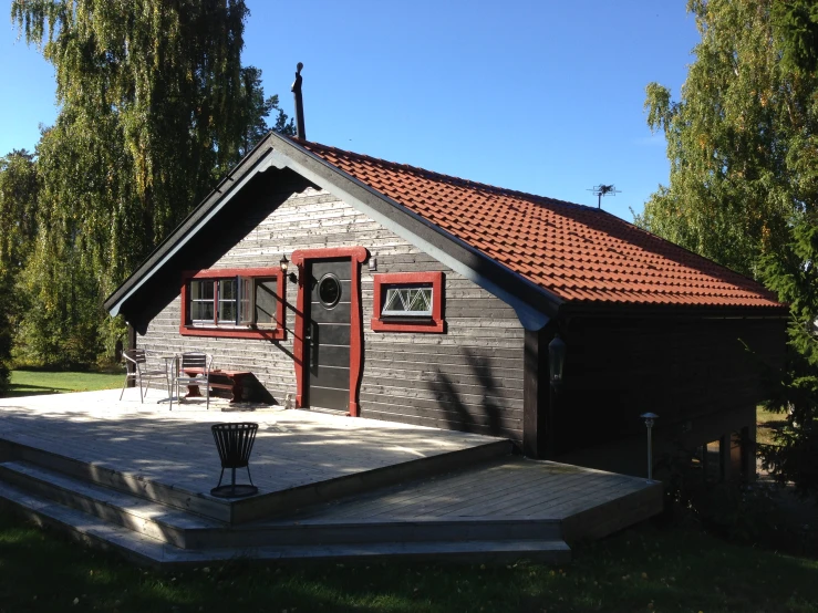 a cabin building with red tile roof next to grass