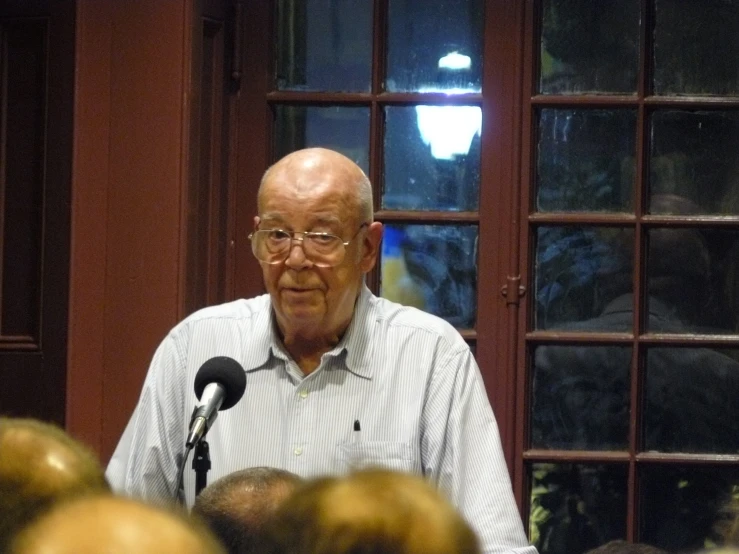 an older gentleman with eye glasses speaking at a conference