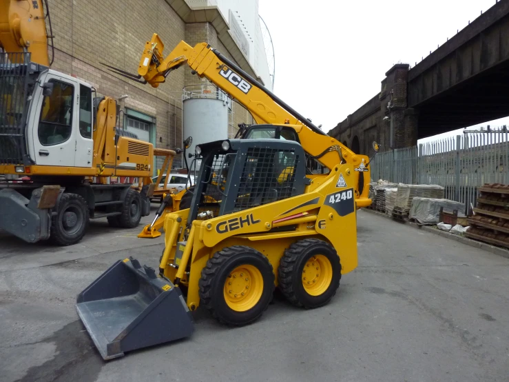 a yellow and black cat is in front of some construction equipment