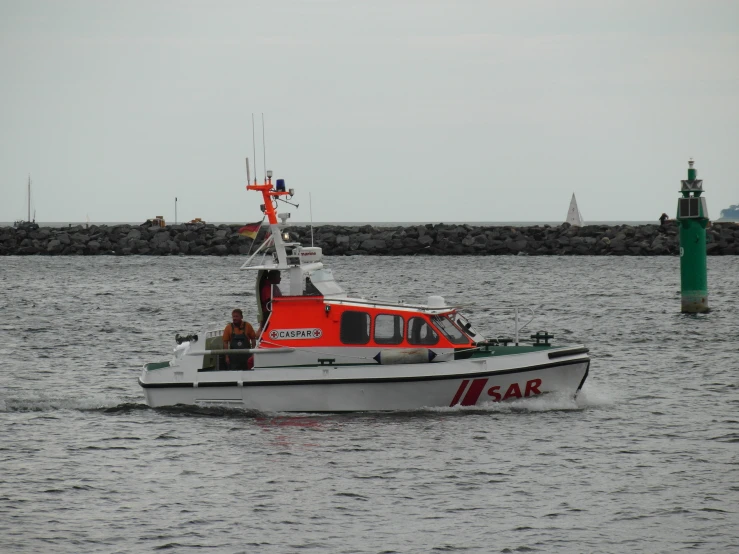 a boat traveling along the shore with people on it