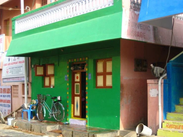 an exterior view of a building with a green door and bike