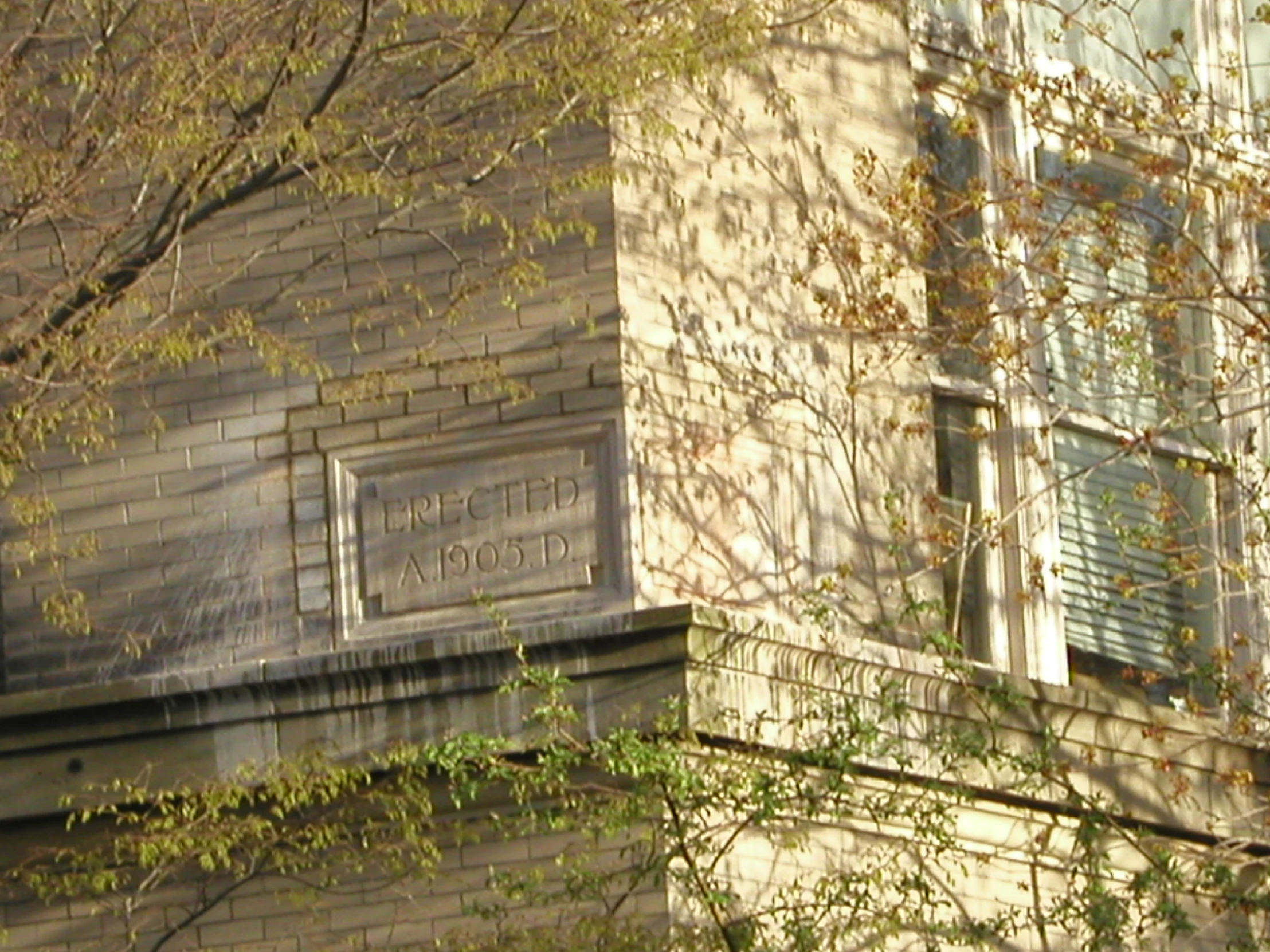 an old brick building in the city with a sign outside