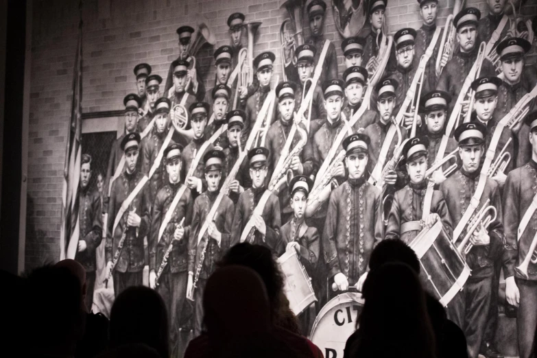 people watching an old time picture on the wall