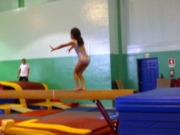 a girl jumps on an above ground trampoline at a playground