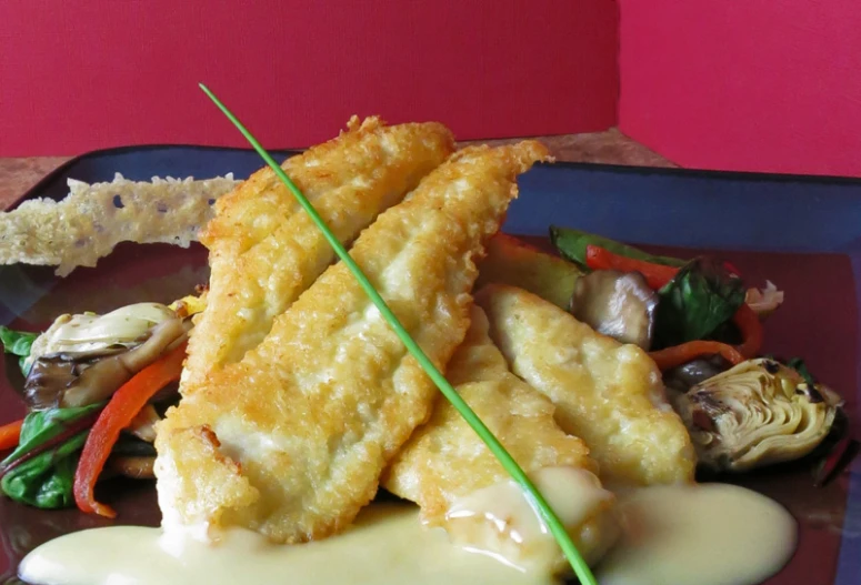 a plate of fried food and dressing with green onions