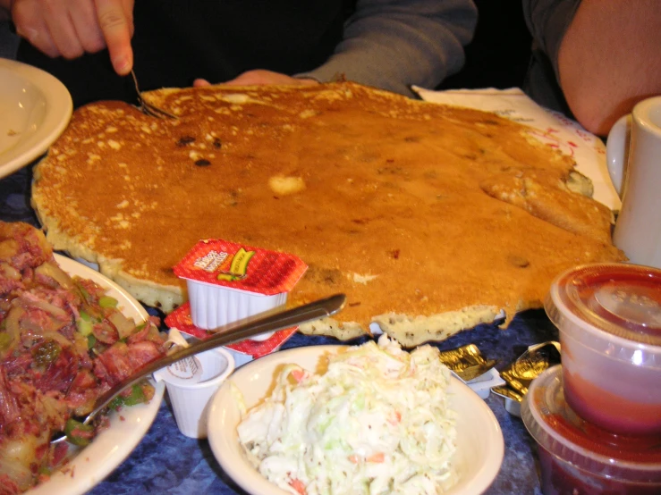 pancakes are sitting on top of the table as people eat