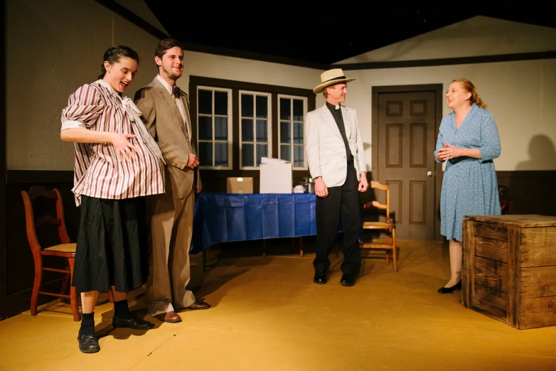 four people dressed in 1940s era clothing standing on stage