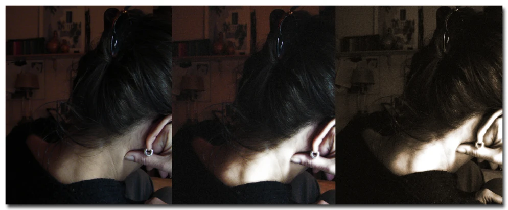 a woman with ear piercings standing in a dark room