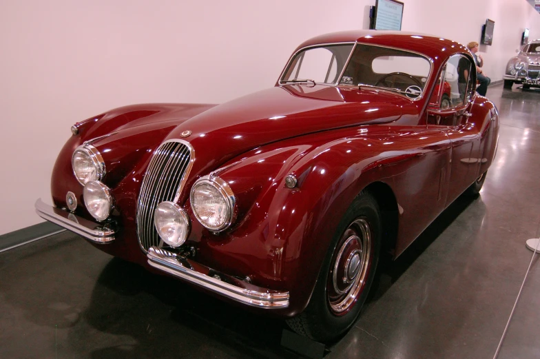 a classic red car on display at a museum