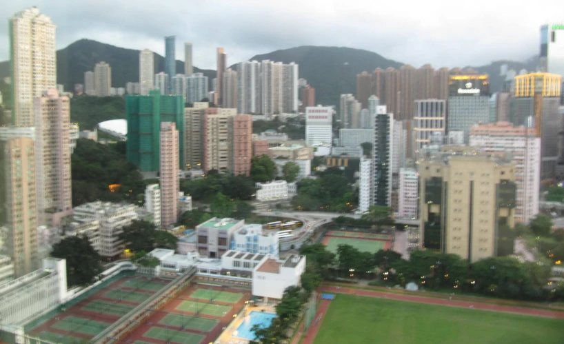 a city with a tennis court in the middle and other buildings