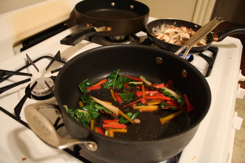 a pan full of vegetables being stirred with a knife