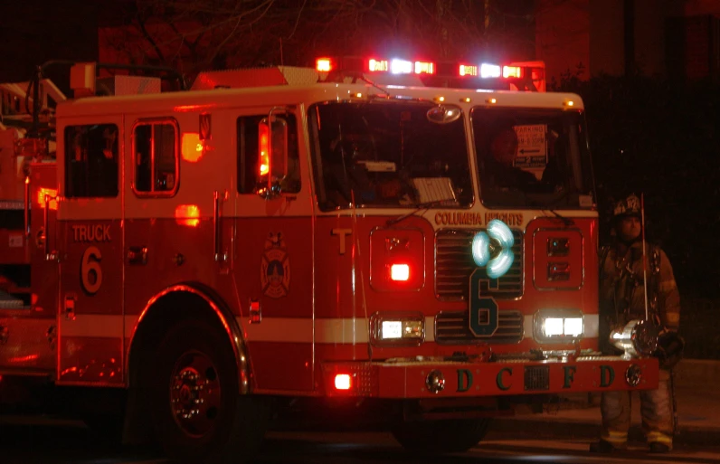 a fire truck at night with the lights on